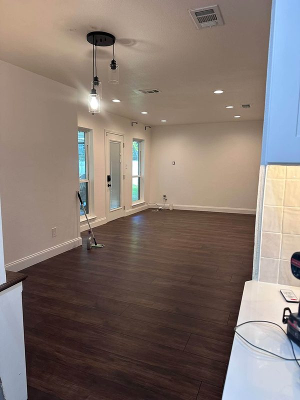 New wood look plank floor in an open living room with a pendant light