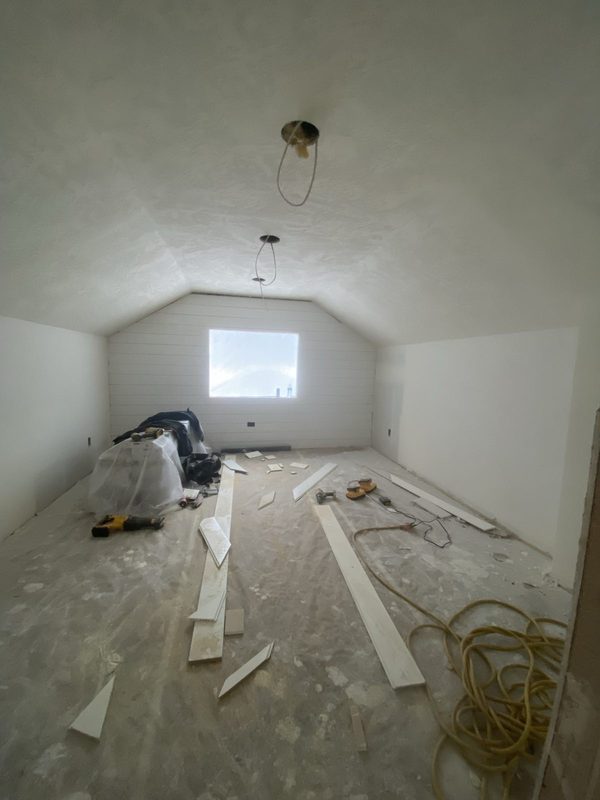 Attic room drywalled with trim staged on the floor